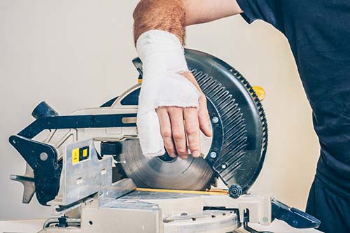 Bandaged finger laceration with the power tool that caused it