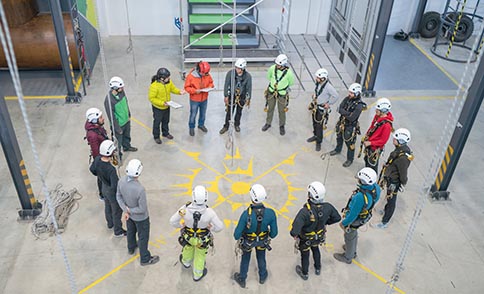 Workers in a Safety360 circle with manager checking PPE